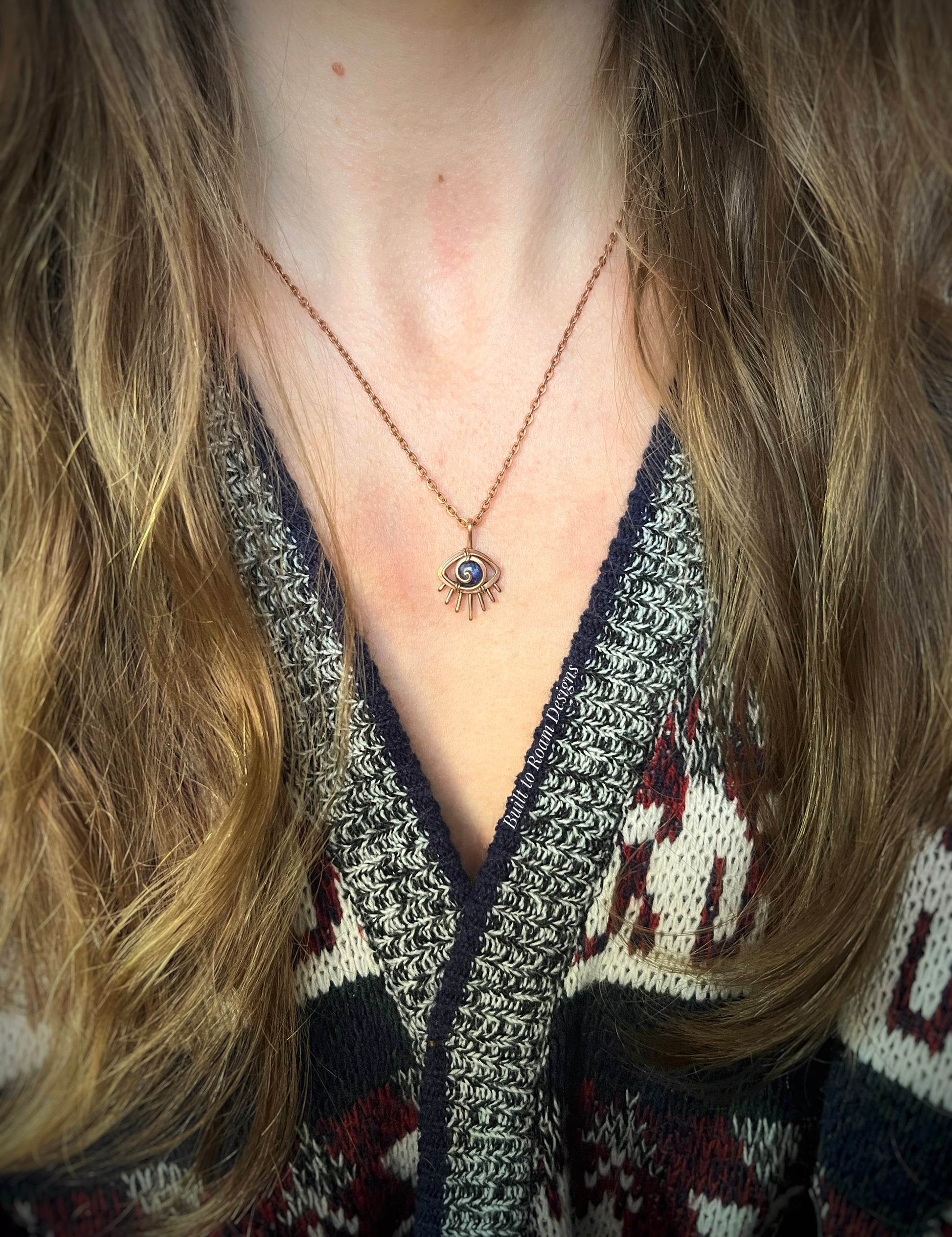 Person wearing a Copper eye-shaped pendant necklace with a blue Sodalite gemstone - front view - Insight