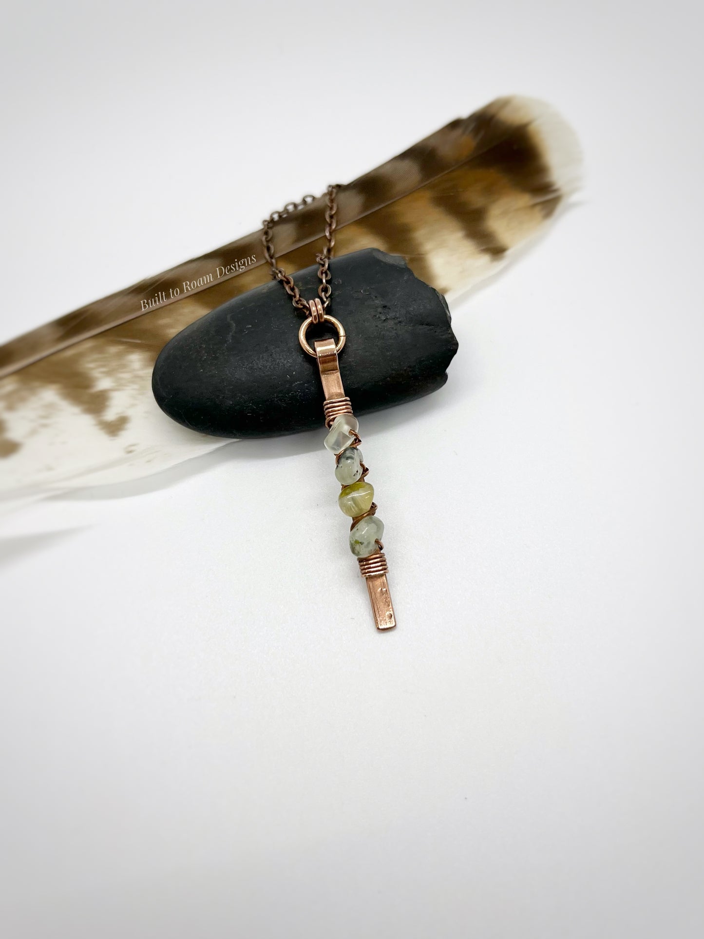 Copper bar necklace with green prehnite chip beads on a rock - front view - Thrive 