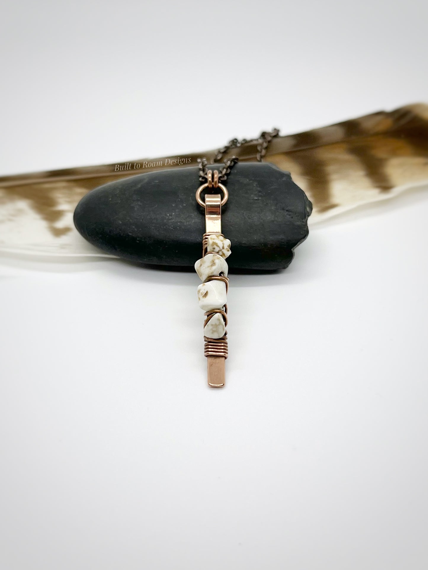 Copper bar necklace with white turquoise chip beads on a rock - side view - Horizon 