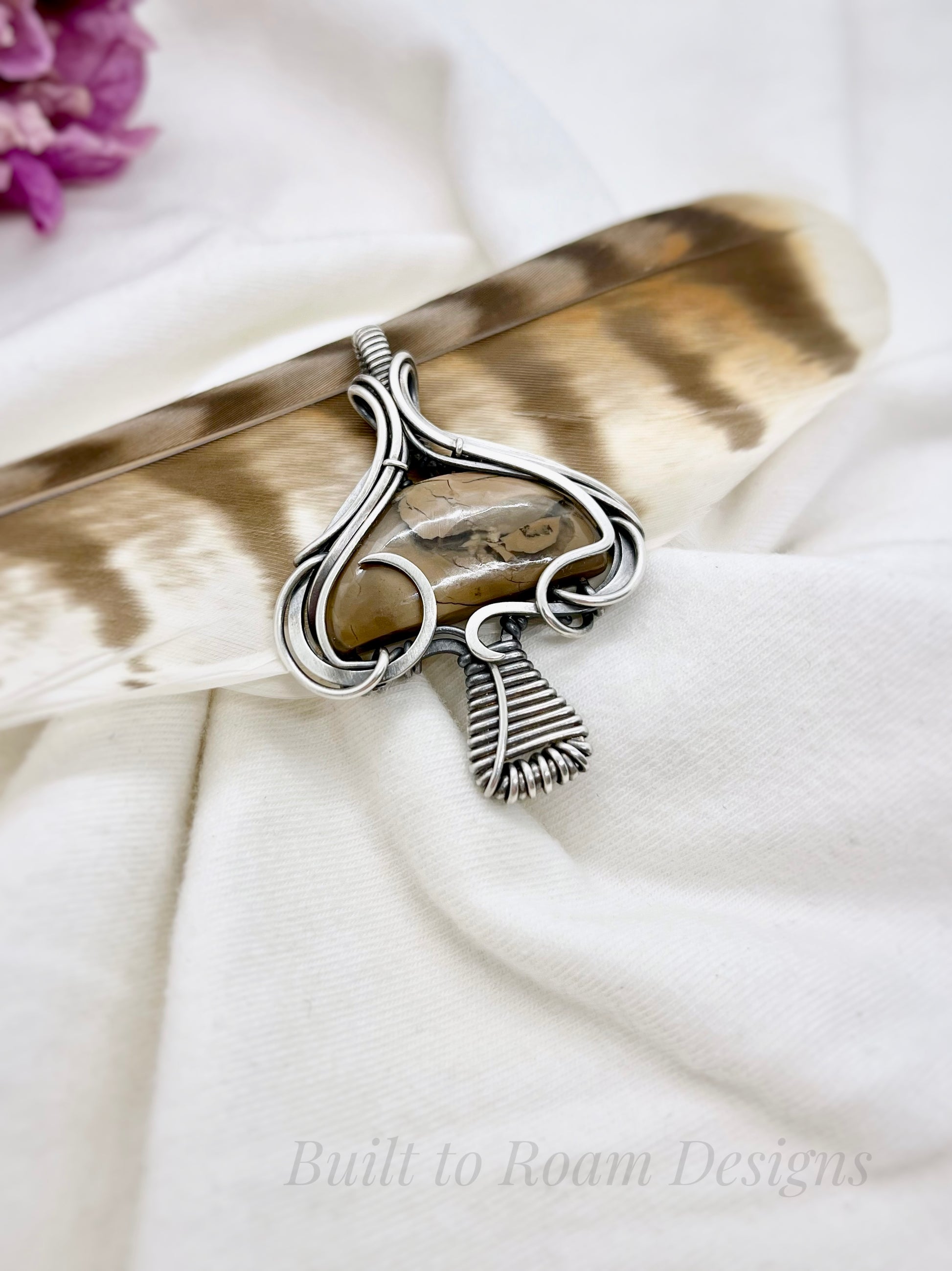 Silver mushroom-shaped pendant with a brown Mookaite Jasper gemstone on white fabric background - side view