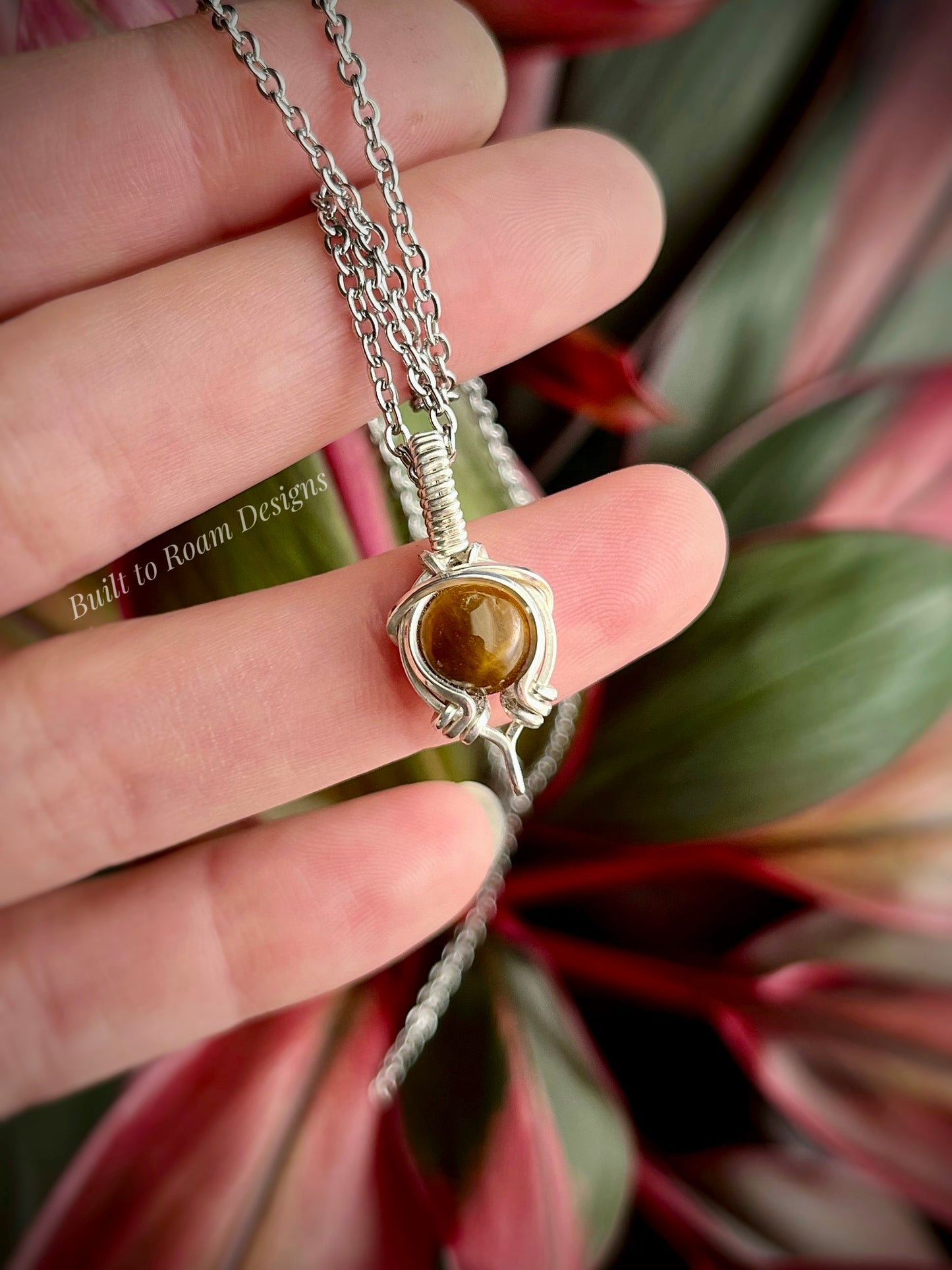 Hand holding Tiger’s Eye pendant necklace from Tiny But Mighty collection in silver, front view 