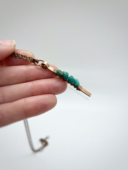 Hand holding a Copper bar necklace with teal amazonite chip beads with white background - side view - Origin