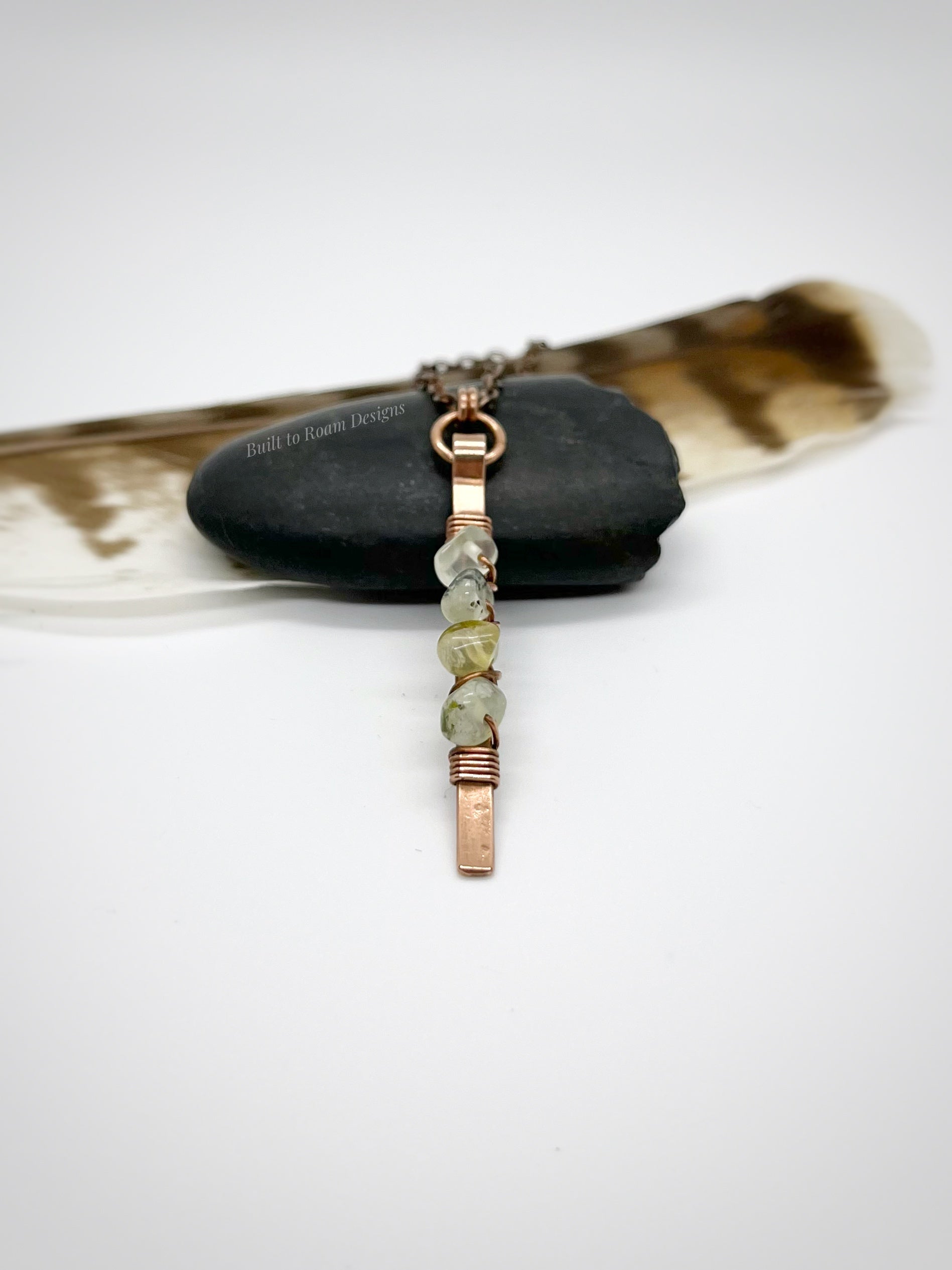 Copper bar necklace with green prehnite chip beads on a rock - side view - Thrive 