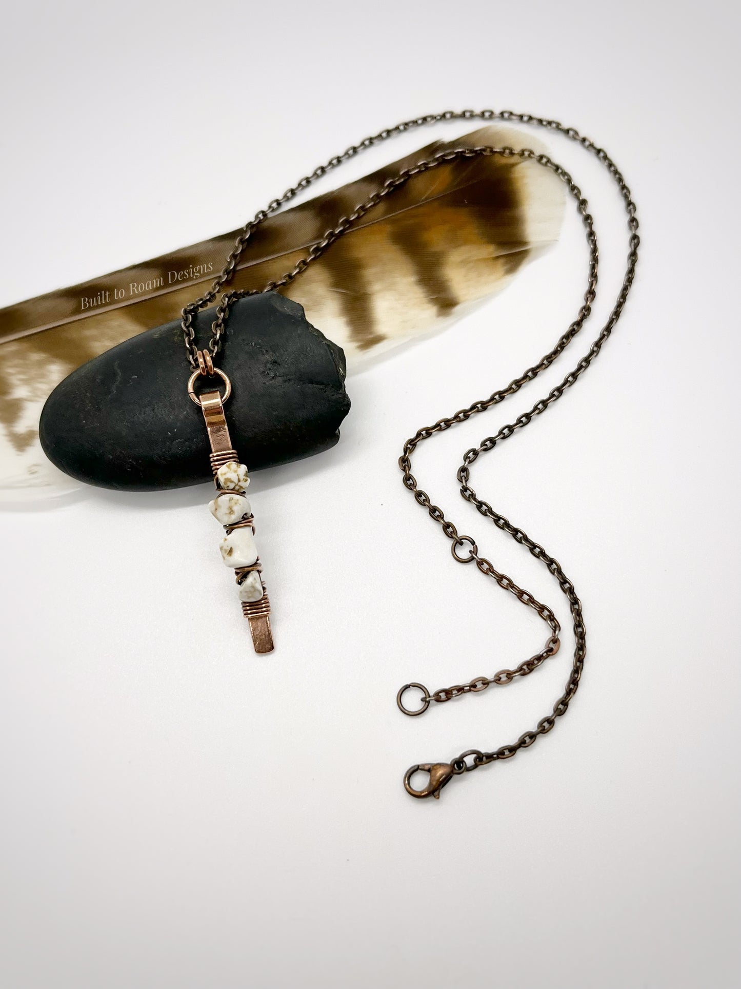 Copper bar necklace with white turquoise chip beads on a rock and white background - front view - Horizon 