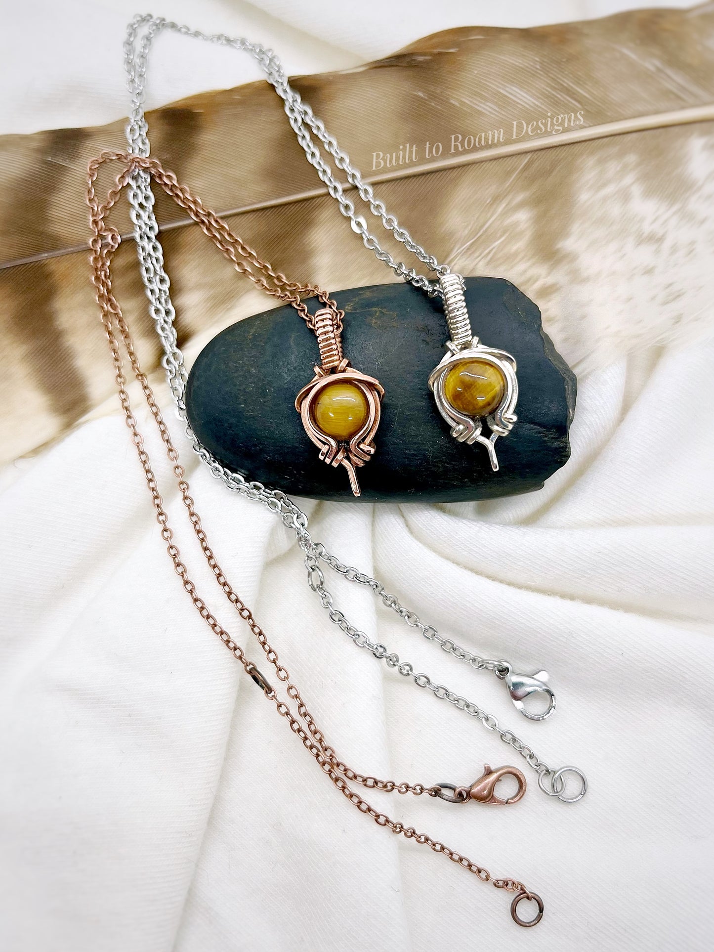 Tiger’s Eye pendant necklace from Tiny But Mighty collection, silver and copper, front view on dark stone