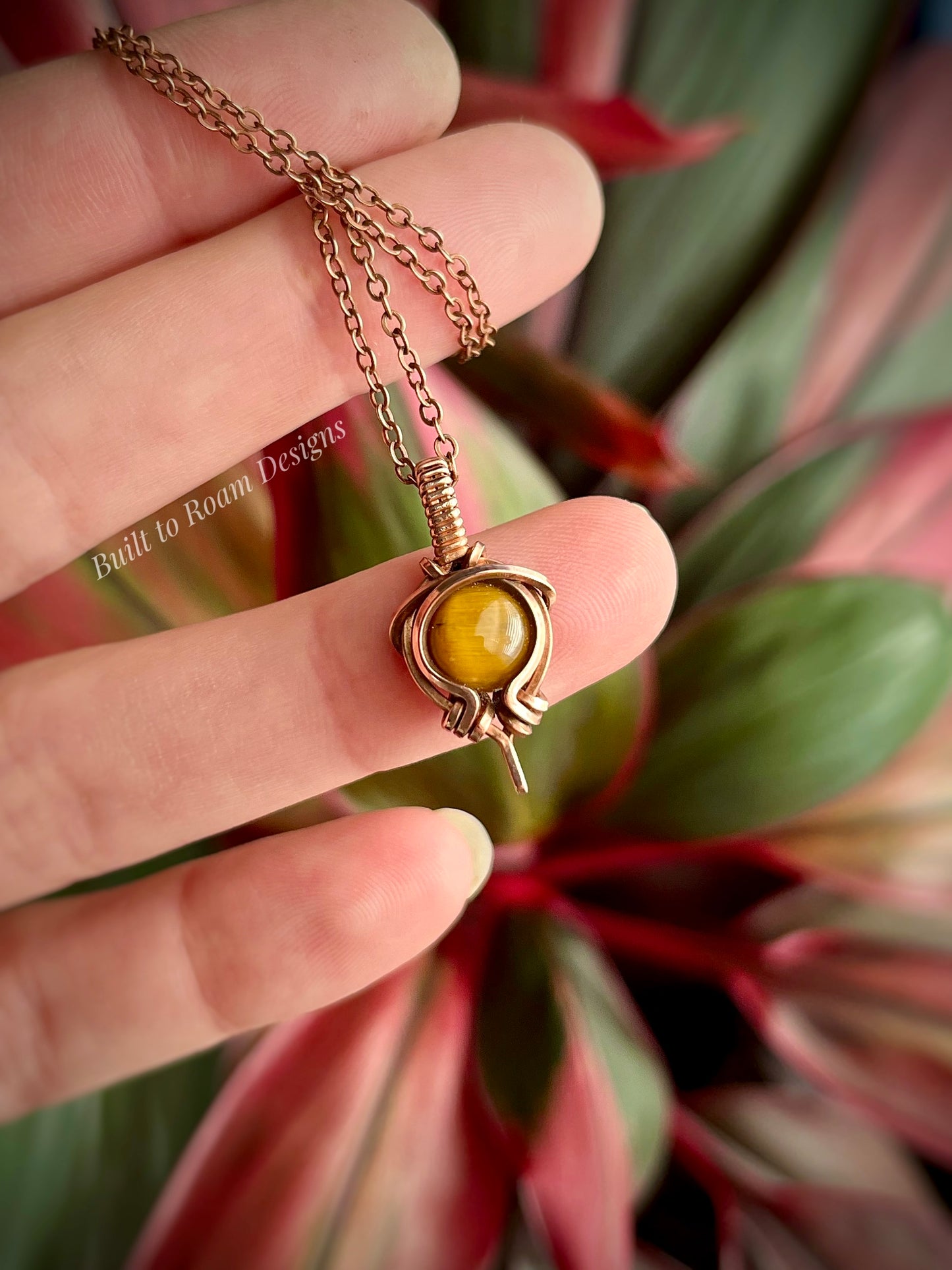 Hand holding Tiger’s Eye pendant necklace from Tiny But Mighty collection in copper, front view 