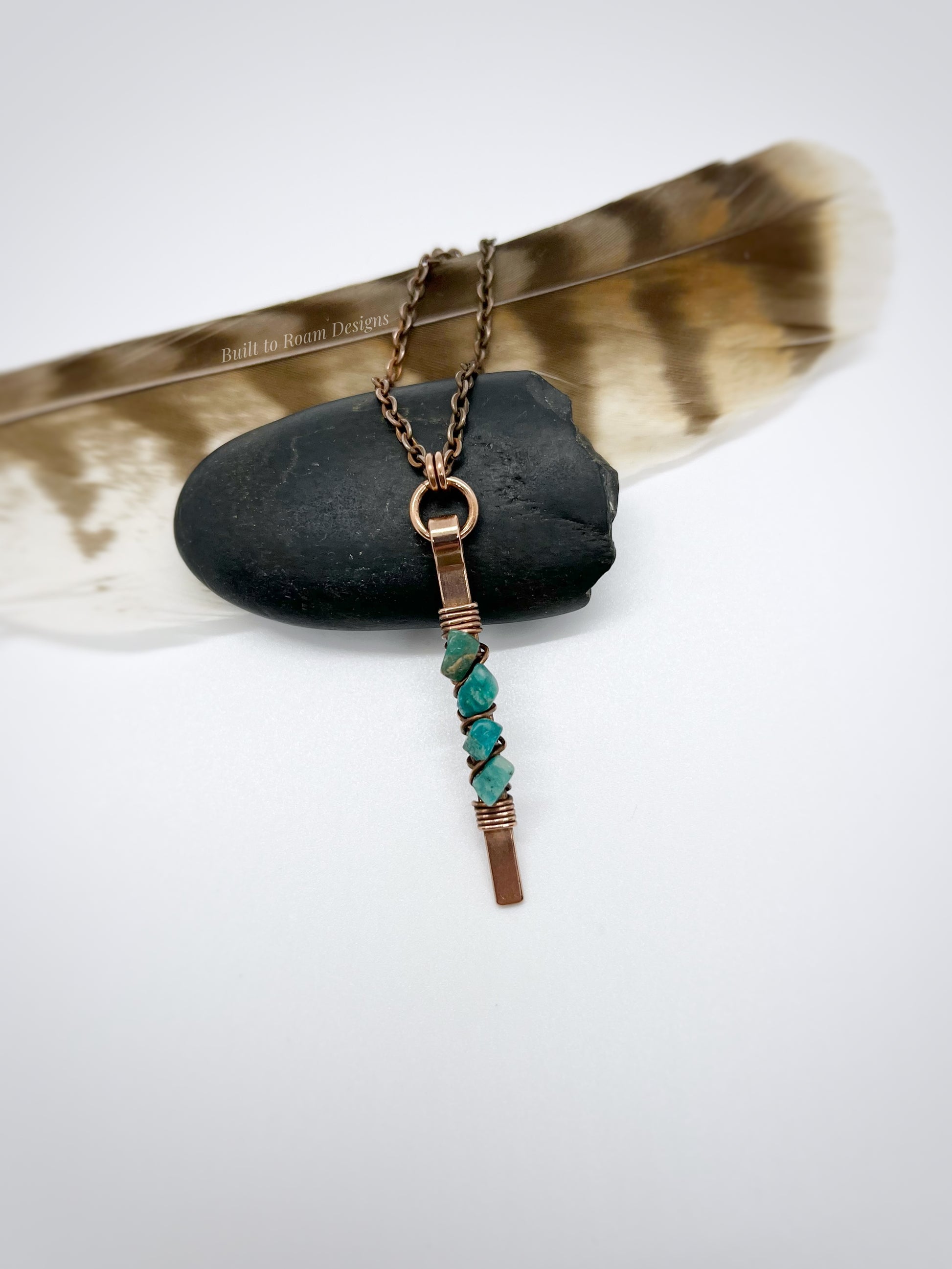 Copper bar necklace with teal amazonite chip beads on a rock with white background - front view - Origin