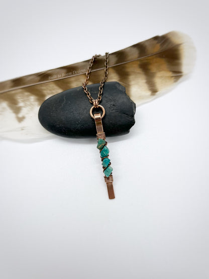 Copper bar necklace with teal amazonite chip beads on a rock with white background - front view - Origin