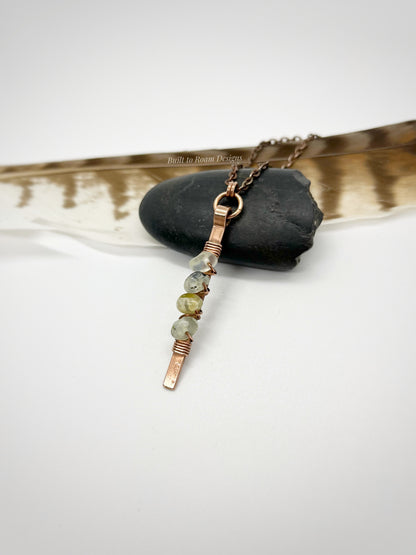 Copper bar necklace with green prehnite chip beads on a rock - side view - Thrive 