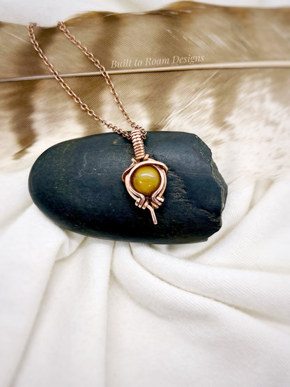 Tiger’s Eye pendant necklace from Tiny But Mighty collection in copper, front view on dark stone