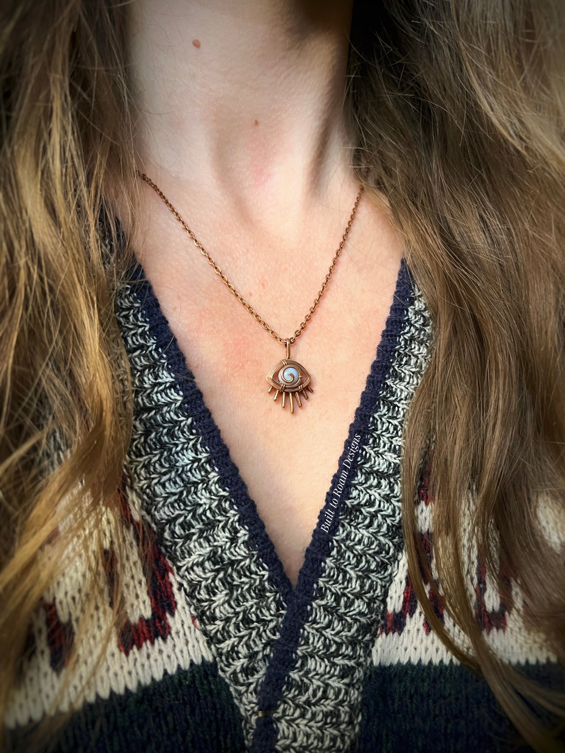Person wearing a Copper eye-shaped pendant necklace with a blue lace agate gemstone - side view - Comfort