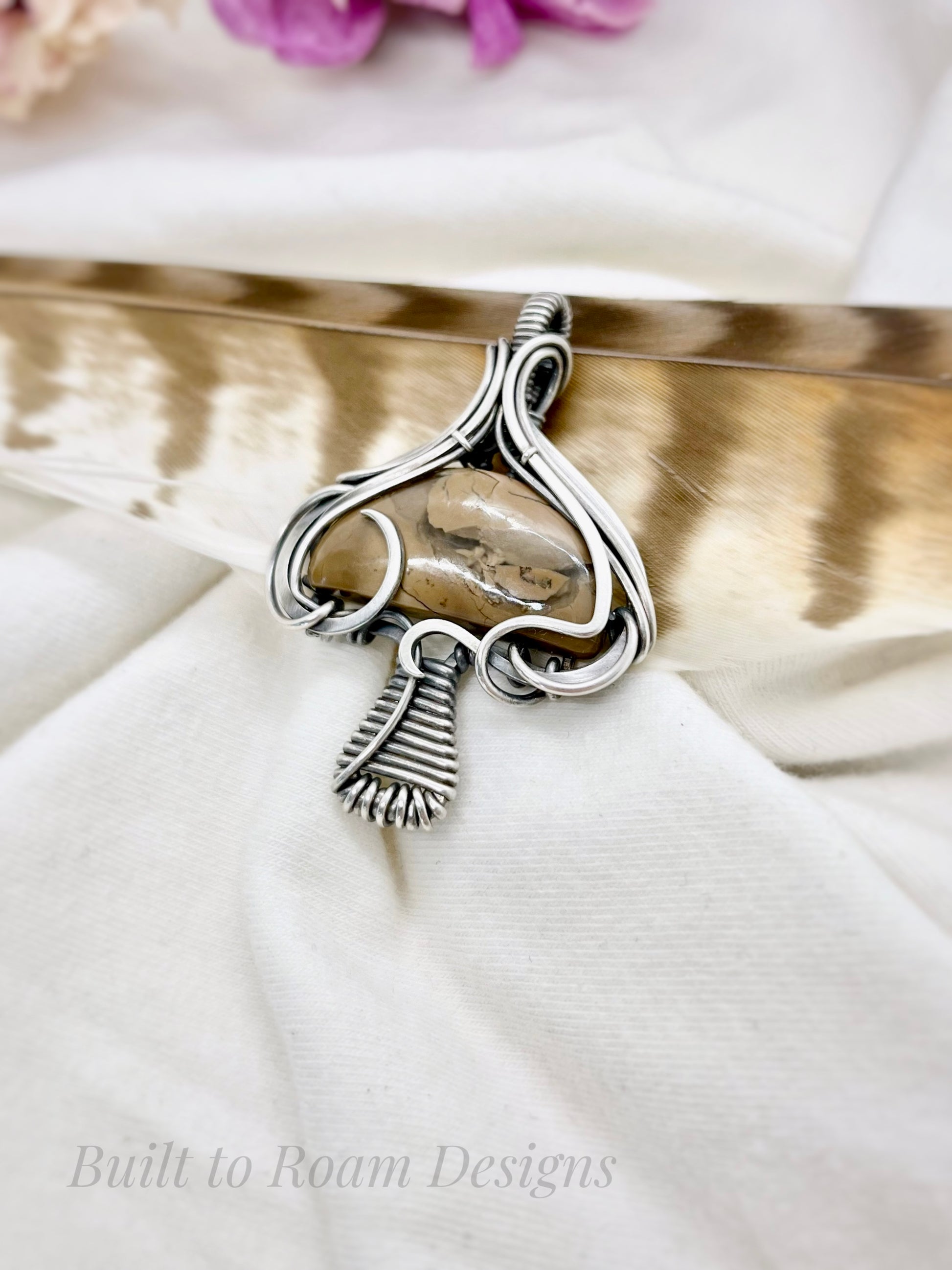 Silver mushroom-shaped pendant with a brown Mookaite Jasper gemstone on white fabric background - side view