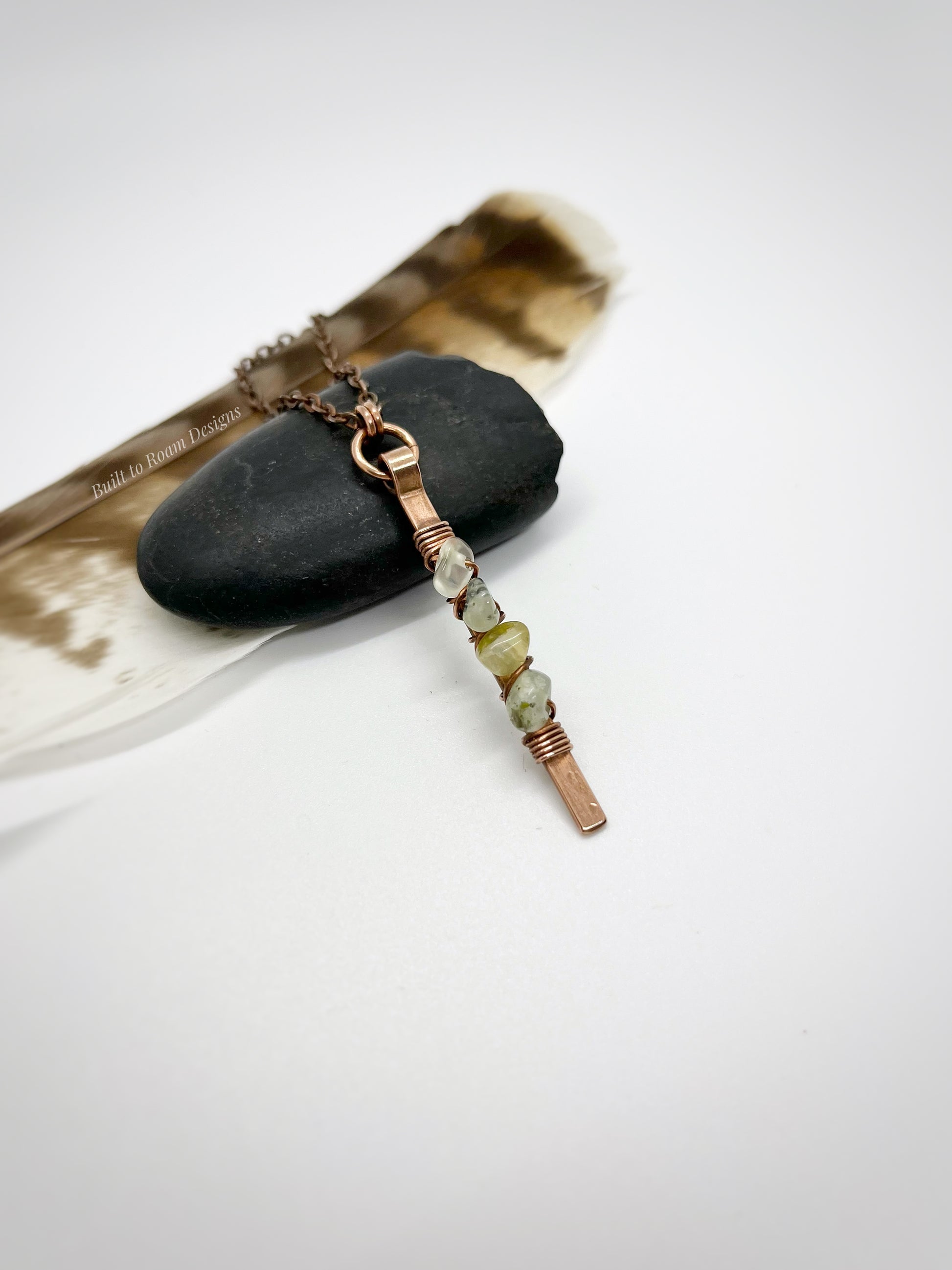 Copper bar necklace with green prehnite chip beads on a rock - side view - Thrive 