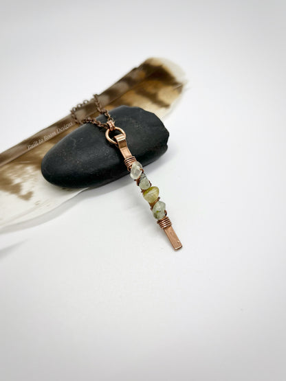 Copper bar necklace with green prehnite chip beads on a rock - side view - Thrive 