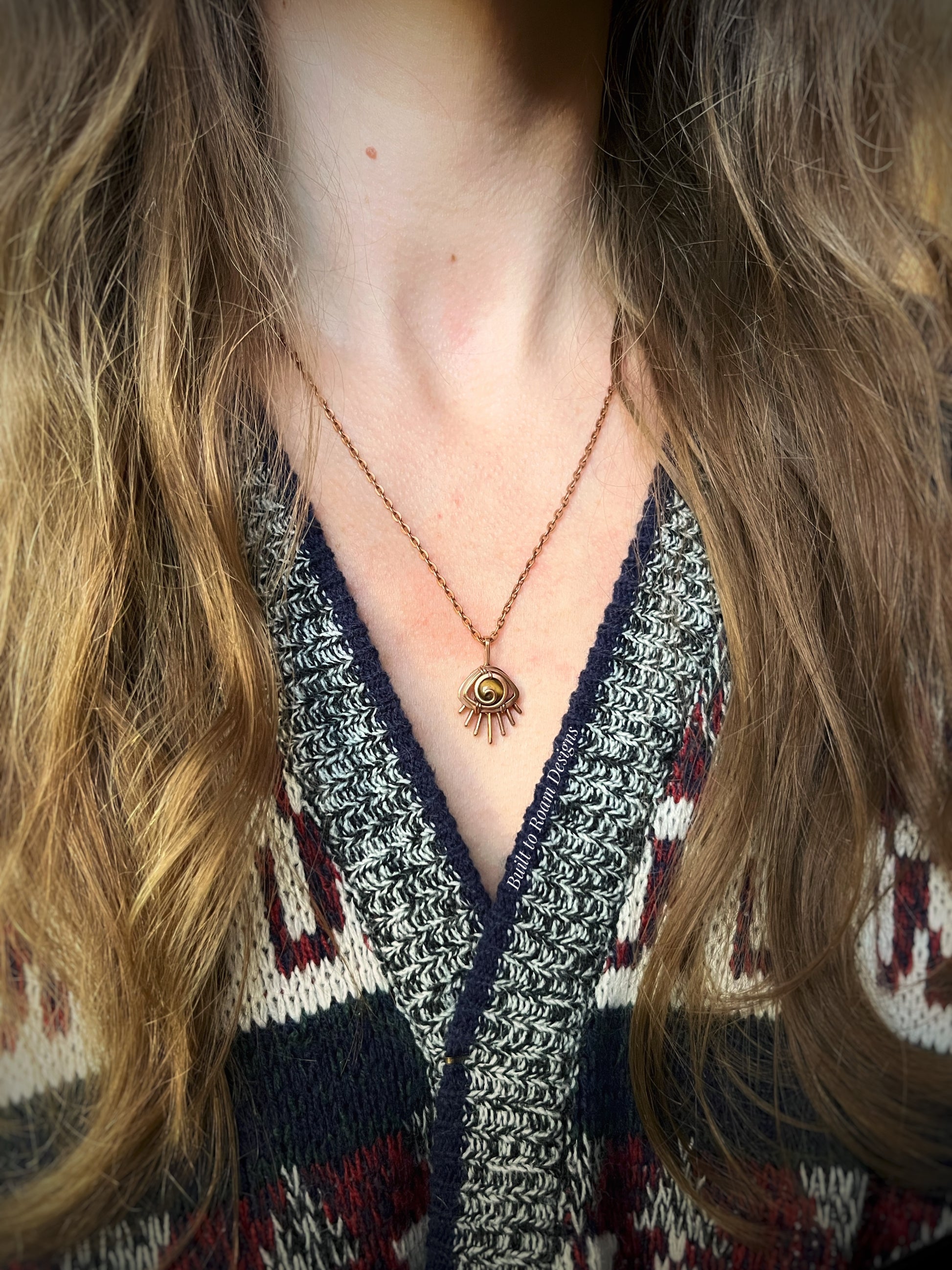 Person wearing a Copper eye-shaped pendant necklace with a golden Tiger’s Eye gemstone - side view - Guardian