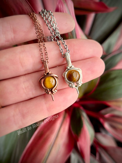 Hand holding Tiger’s Eye pendant necklace from Tiny But Mighty collection, silver and copper, front view 