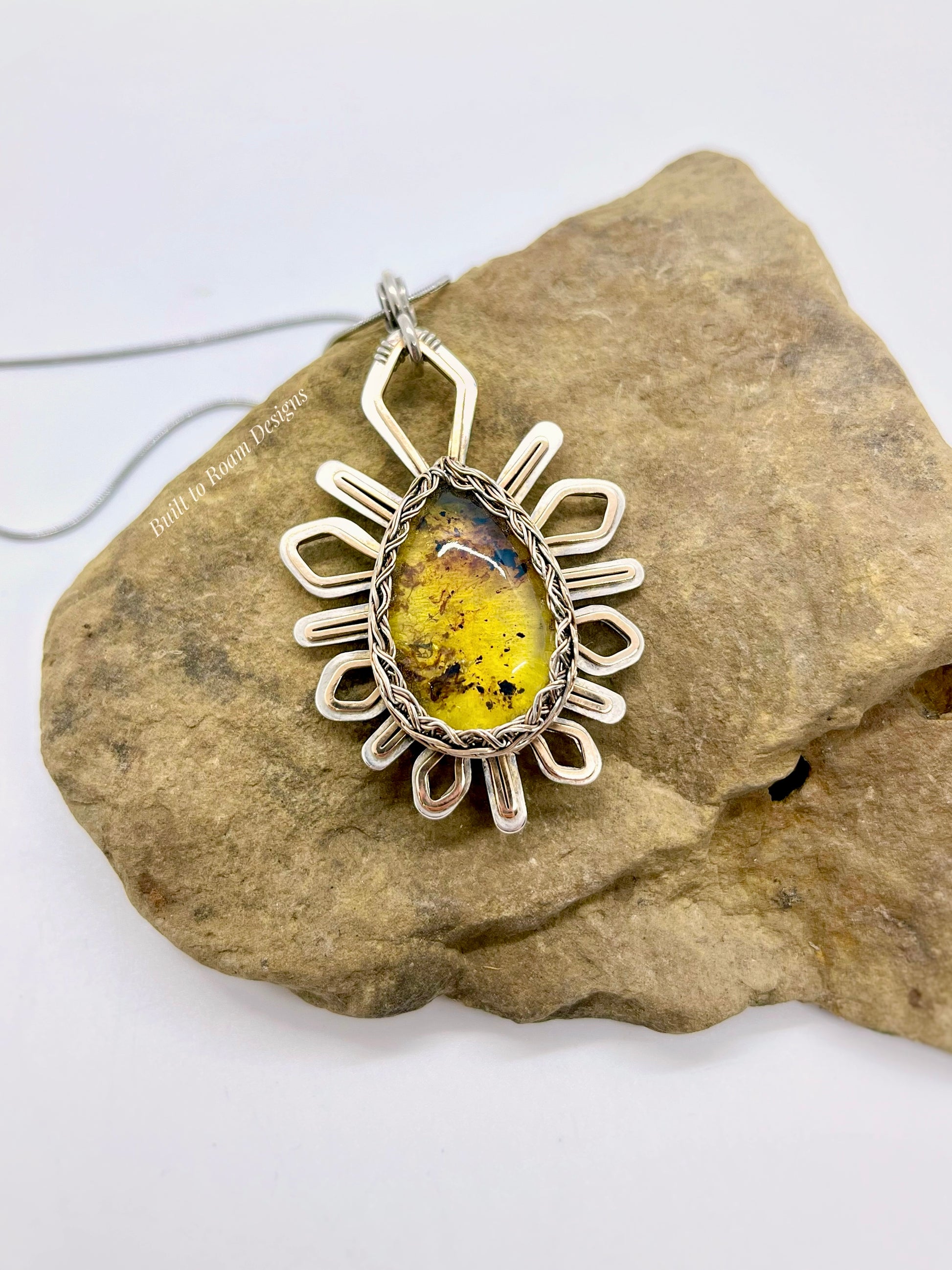Silver and Bronze pendant with golden amber stone on a rock - Liora
