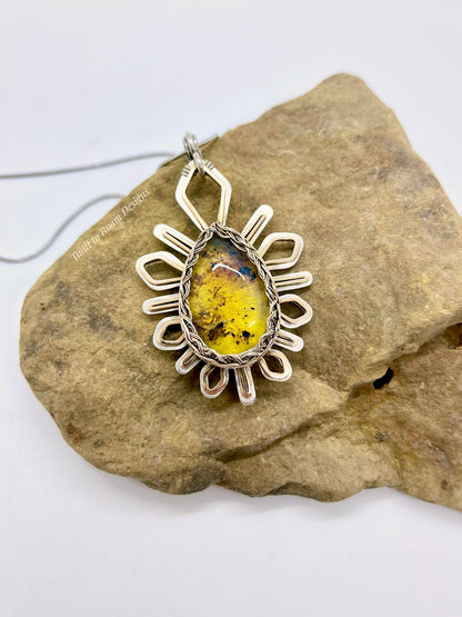Silver and Bronze pendant with golden amber stone on a rock - Liora